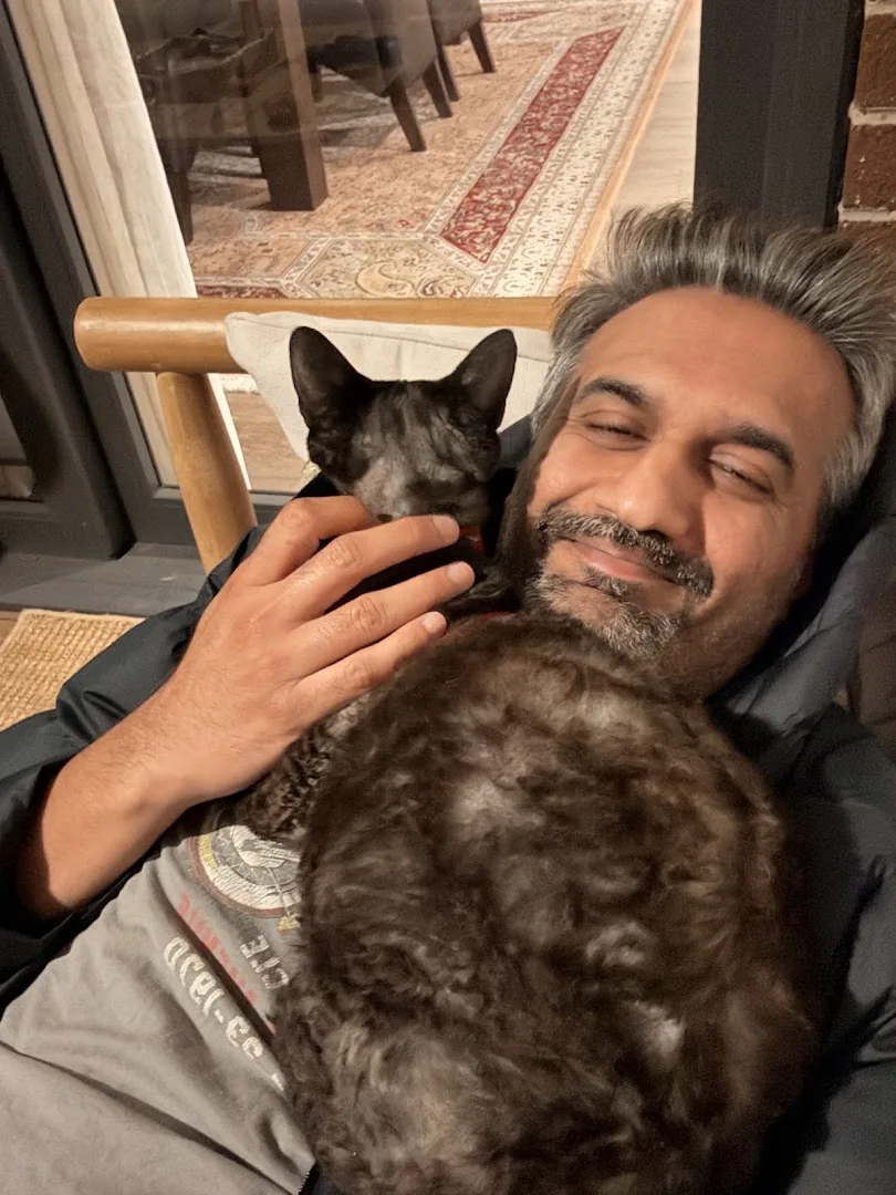 One of the Meow Minders family cuddling a sleepy cat at home